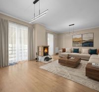 Living room in a family house with a wooden decor floor, a fireplace, and a corner sofa.