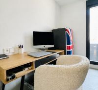 A work corner with a wooden desk and chair in a 3-room apartment.