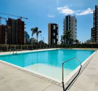A pool surrounded by buildings in Calpe, ideal for a 3-bedroom apartment with modern amenities.
