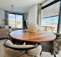 Dining table with comfortable chairs in a 3-room apartment with large windows.