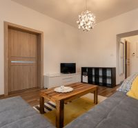 Living room in a two-room apartment with a sofa, table, and lamp.