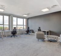 Offices with large windows, gray walls, and modern furniture.