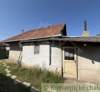 A family house in Šurany with a gable roof and a window, surrounded by a lawn.
