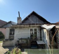 An older family house in Šurany with a wooden roof and a chimney.