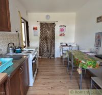 A kitchen in a 2-room apartment with a stove, sink, and a floor with a wooden decor.