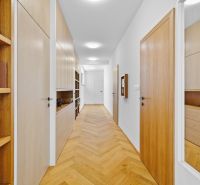 A hallway with a wood-patterned floor and built-in wardrobes in a 4-room apartment.