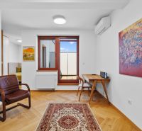 A living room with a chair, paintings, and a wooden decor floor in a 4-room apartment.