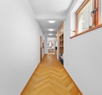 A hallway with a built-in bookshelf and a wooden decor floor in a 4-room apartment.