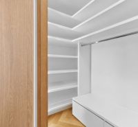 A wardrobe room in a 4-room apartment with shelves and a floor with a wooden decor.