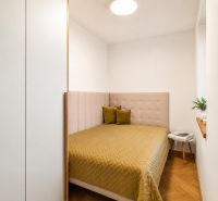 Bedroom in a 4-room apartment with a bed, pillows, and a table, floor with wooden decor.