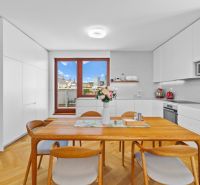 A kitchen in a 4-room apartment with white cabinets and a wood-patterned floor.