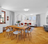 Living room in a 4-room apartment with a wooden decor floor and a large dining table.