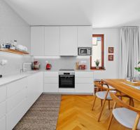 A kitchen in a 4-room apartment with white cabinets and a wood-patterned floor.