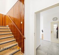 A staircase with wooden paneling and a mirror in a family house.