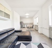 Living room with a sofa, dining table, and large windows in a family house.