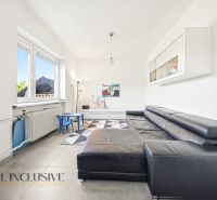 Living room in a family house with a sofa, children's chairs, and a large window.