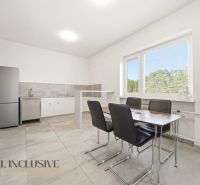 Dining room in a family house with a simple kitchen unit and a dining table.