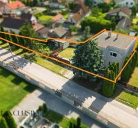 A family house in Topoľníky with a large plot lined with trees and an orange line.