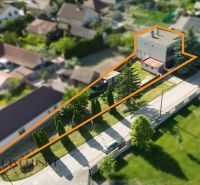 A family house in Topoľníky with a plot of land, bordered by greenery and an access road.