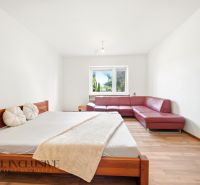 A bedroom in a family house with a red sofa and a wooden decor floor.