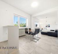 Dining area with dark furniture in a family house and living zone with a sofa.