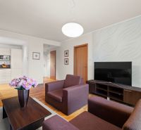 Living room in a two-room apartment with a wooden decor floor and modern furniture.