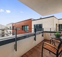 A balcony with wooden decor and furniture, view of the surrounding buildings.