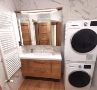 Bathroom in a 2-room apartment with a washing machine, sink, and retro radiator. Floor with wood decor.