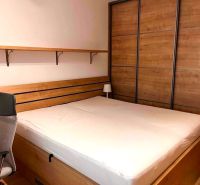 Bedroom with a bed and a built-in wardrobe, in a 2-room apartment.