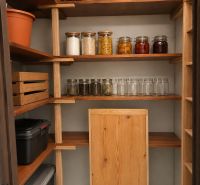 Pantry with shelves, storage boxes, and jars in a three-room apartment.