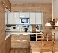 A kitchen in a 2-room apartment with a wooden decor and a dining table.