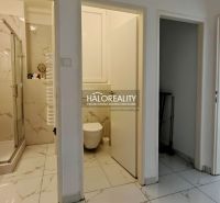 The interior of the bathroom and toilet in a 2-room apartment with marble-patterned tiles.