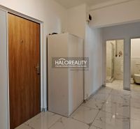 A corridor with an entrance door, a cabinet, and an open entrance to the bathroom in a 2-room apartment.