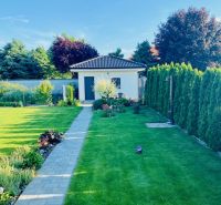A well-maintained lawn and pathway next to a family house on Jasná Street in Veľké Dvorníky.