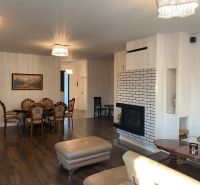 Living room in a family house with a fireplace and a wooden decor floor.