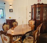 Dining room in a family house with historical furniture and a wooden decor floor.