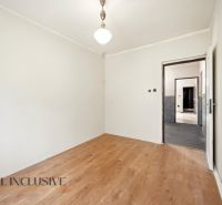 A room in a family house with white walls and a wooden decor floor.