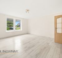 A bright room with a wooden decor floor and a large window in a family house.