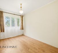 A room in a family house with a window, curtains, and a floor with a wooden decor.