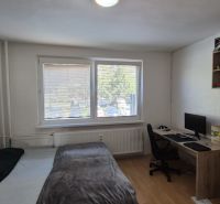 A room in a 3-room apartment with a bed, a desk, and a floor with a wooden decor.
