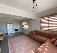 Kitchen and living room of a 3-room apartment with a sofa, dining table, and kitchen unit.