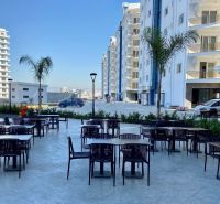 Iskele are visible outdoor spaces with café tables and high-rise buildings.