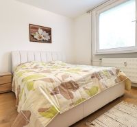 A bedroom in a 3-room apartment, wooden decor flooring, bed, nightstand.