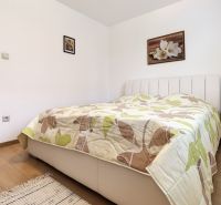 A bedroom in a 3-room apartment with a bed, blanket, and floor with a wooden decor.