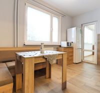 A kitchen in a 3-room apartment with a wooden decor floor and a dining table.