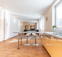 A kitchen in a 3-room apartment with an island and a floor with a wood decor.