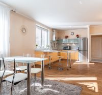 A kitchen in a 3-room apartment with a wooden decor floor and a dining table.