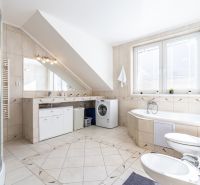 A spacious bathroom with a bathtub, shower, and washing machine in a 3-room apartment.