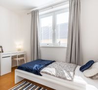 A bedroom with a single bed, a desk, and a wooden floor decor in a 3-room apartment.