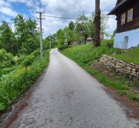 A narrow road path in Terchová surrounded by greenery, ideal for residential plots.